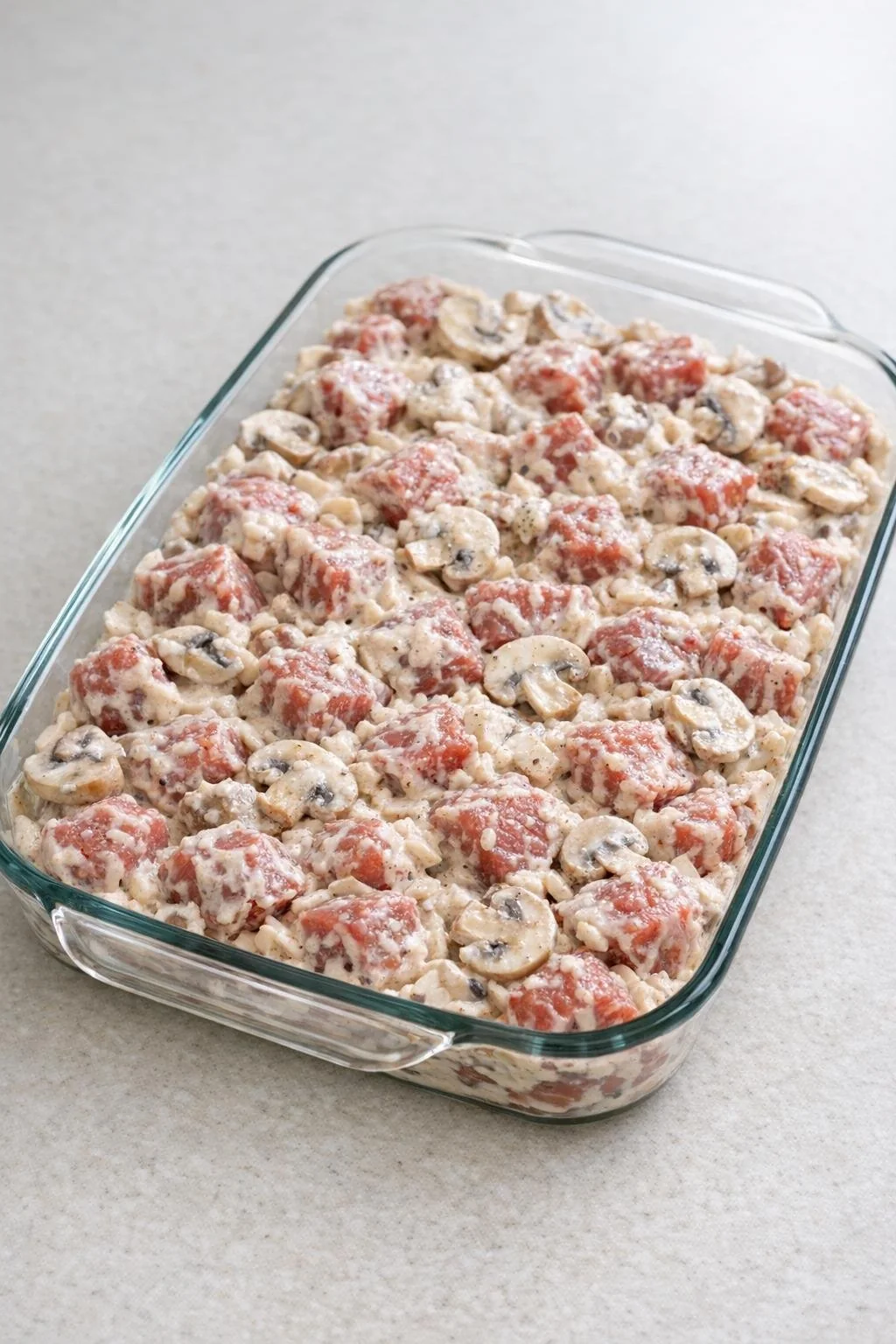 Unbaked Beef Granville mixture spread in a glass casserole dish