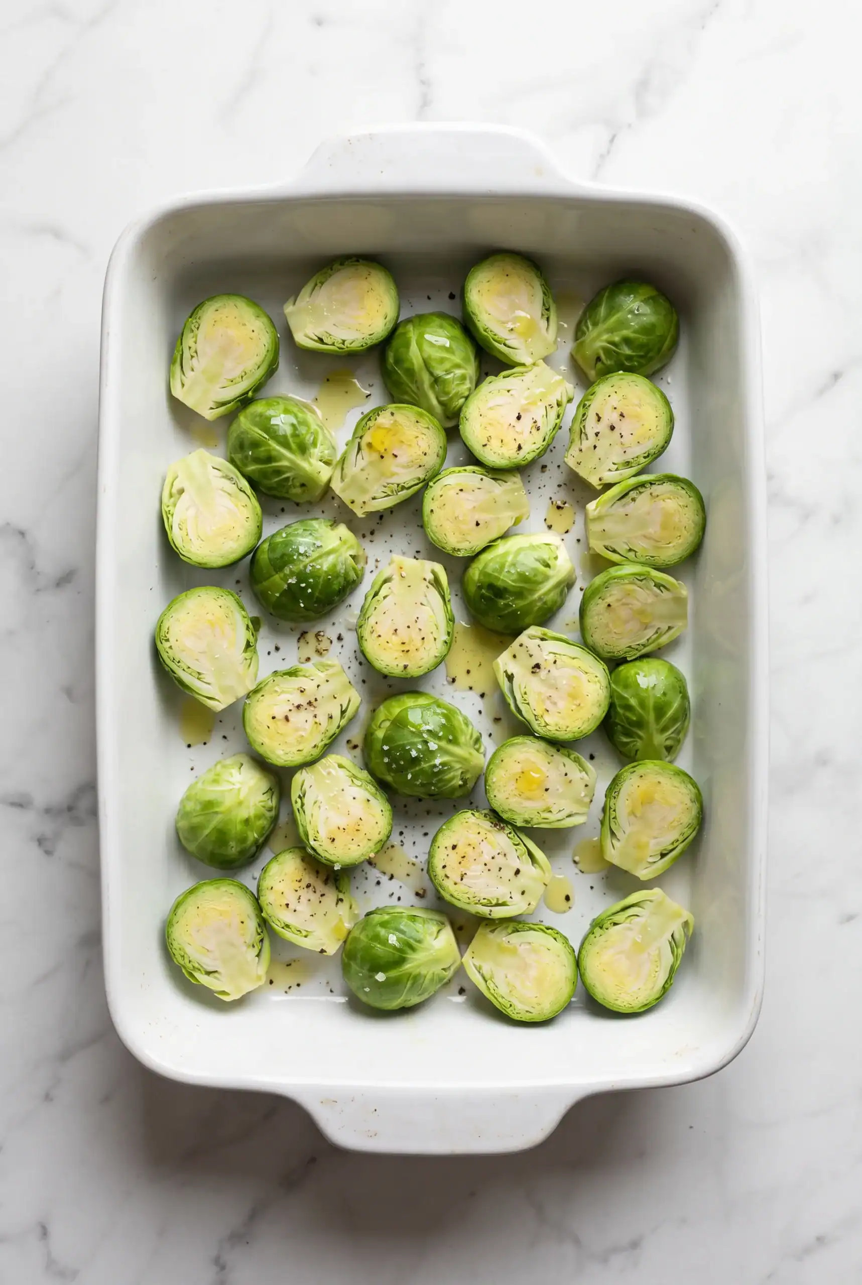 Halved seasoned Brussels sprouts ready for cooking