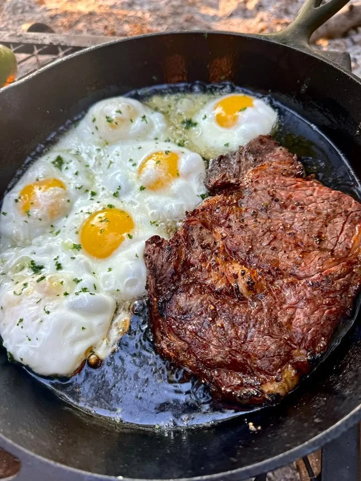 Campfire steak and eggs dish served in a beautiful outdoor setting
