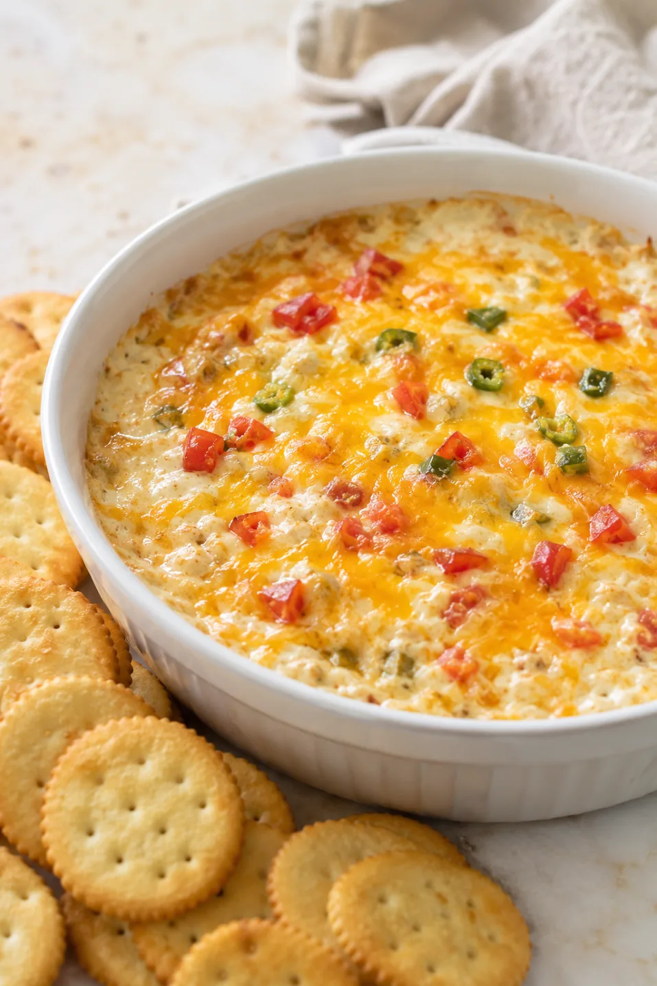Warm baked Cheese Winston Dip in a white bowl with crackers