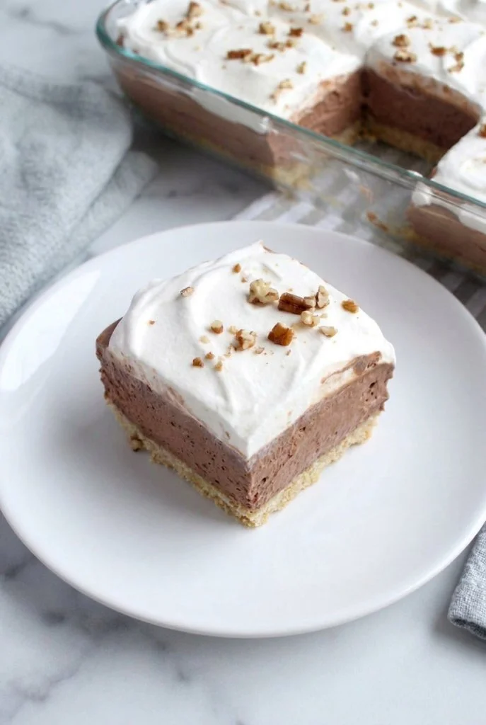 Delicious Chocolate Pecan Delight dessert topped with nuts.