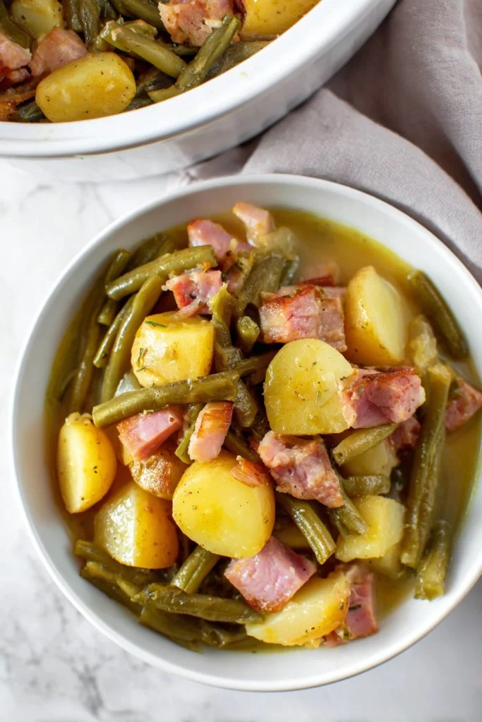 Crockpot Ham served with potatoes and green beans in a cozy setting