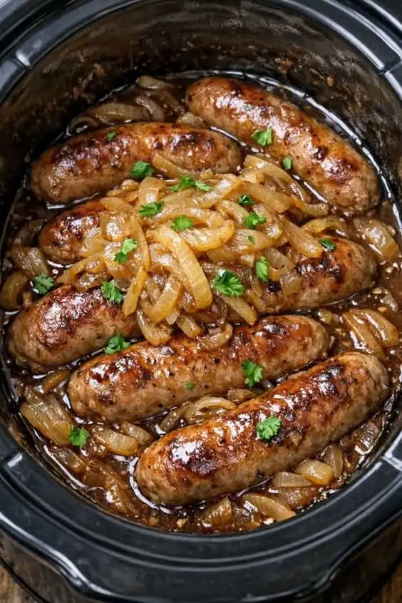 Slow cooker bangers and onions with rich onion gravy and browned sausages.