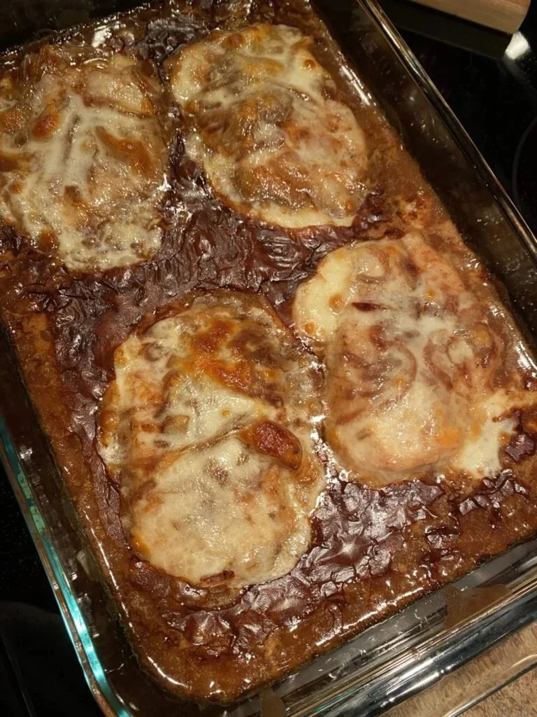 Delicious French Onion Pork Chops served on a plate with melted cheese and caramelized onions.