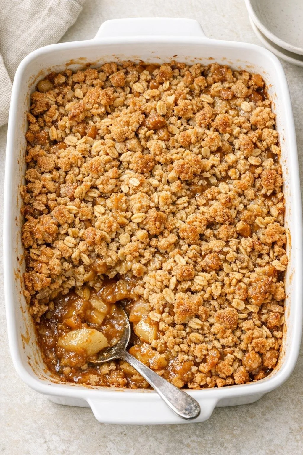 Delicious oven baked caramel apple crisp served in a rustic dish.