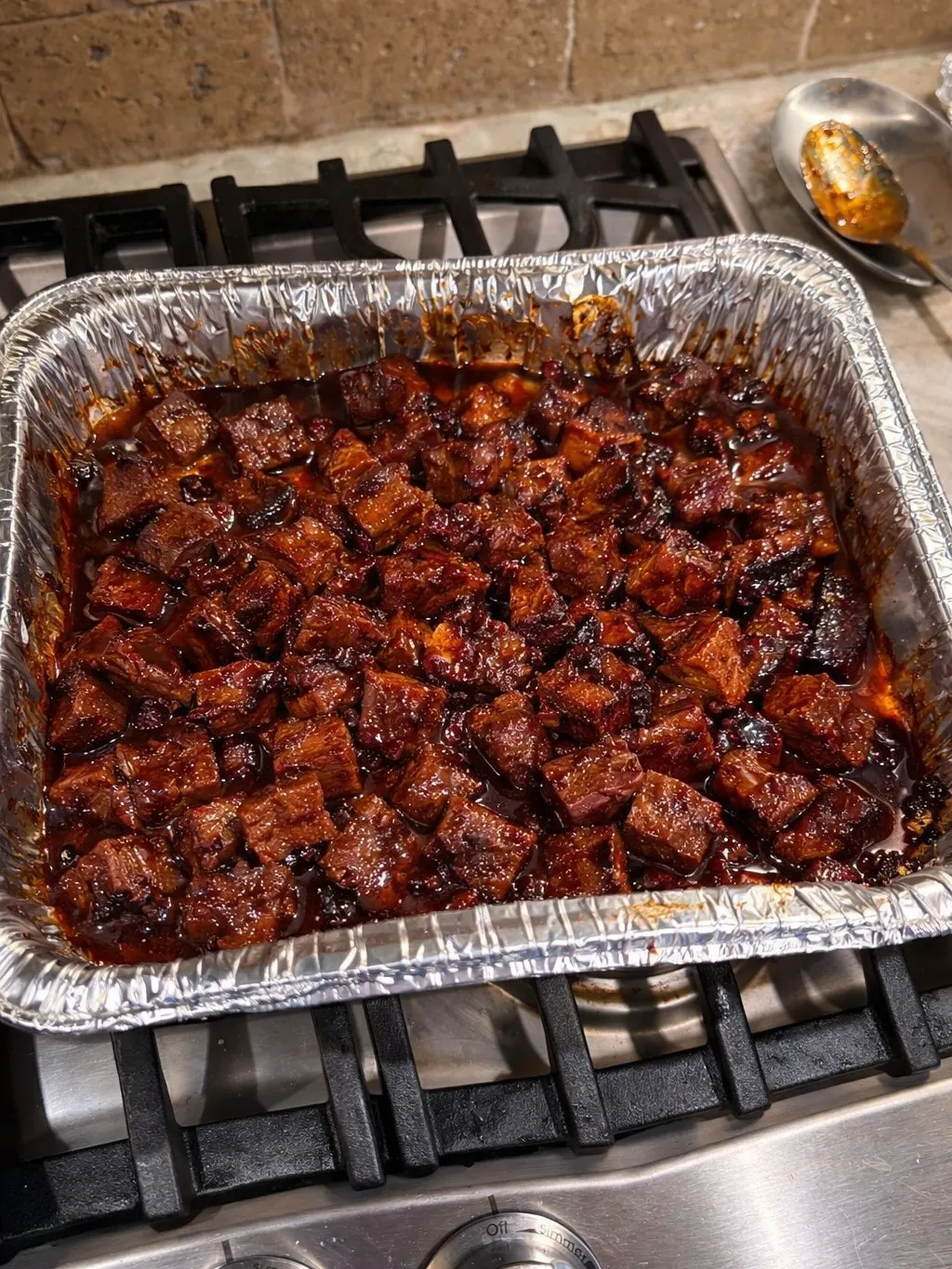 poor man’s burnt ends made with smoked sausage coated in sweet smoky BBQ sauce and caramelized glaze in foil pan