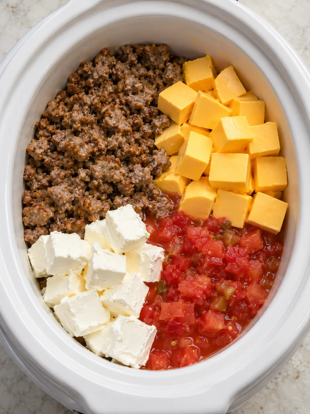 Sausage, two cheeses and tomatoes before melting in a slow cooker