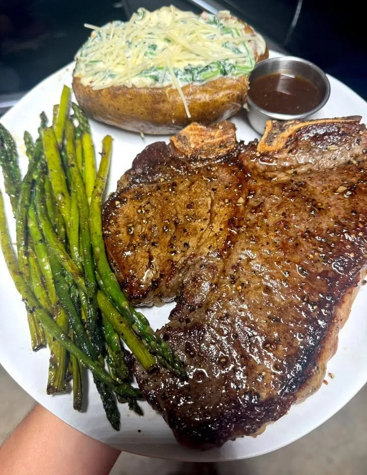 Steak dinner with spinach artichoke dip stuffed baked potato on a plate.